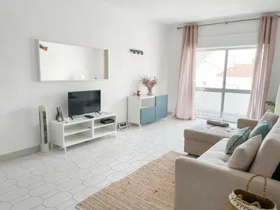 a living room with a couch and a tv at Sunny House Albufeira in Albufeira