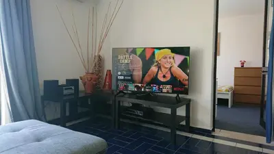 a living room with a flat screen tv on a wall at CASA ROMAN Poente da Aldeia in Albufeira