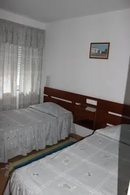a bedroom with two beds and a table and a window at Dom Fernando I in Loulé