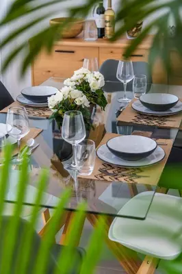 a table with plates and glasses and a vase of flowers at Salgados 2-Bedroom Apartment - 900m from the Beach - Wifi in Guia