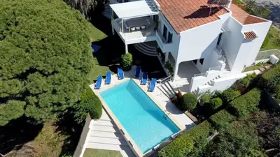 an aerial view of a house with a swimming pool at Villa Hibiscus, great location in Vilamoura, lush green lawns and garden in Quarteira