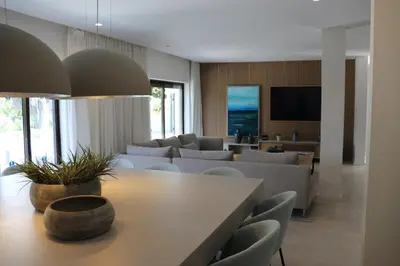 a living room with a table and chairs and a tv at Villa Hibiscus, great location in Vilamoura, lush green lawns and garden in Quarteira