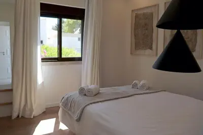 a bedroom with a bed with two towels on it at Villa Hibiscus, great location in Vilamoura, lush green lawns and garden in Quarteira