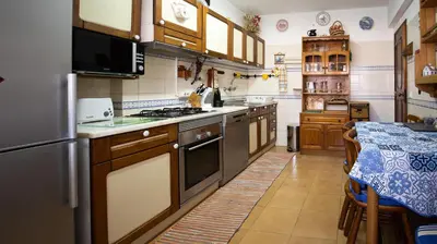 a kitchen with a refrigerator and a stove top oven at Apartamento Pateo - Algarve - BY BEDZY in Albufeira