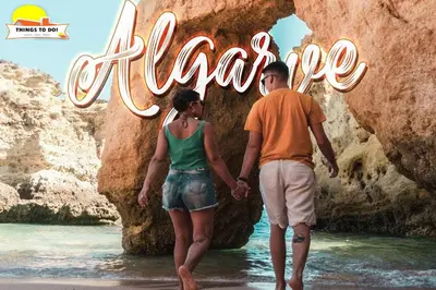a man and woman walking in the water in front of a sign at #098 Casa Antonieta 3 by Home Holidays in Albufeira