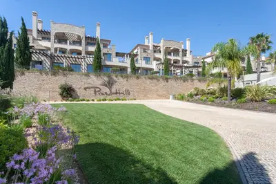 a grassy yard in front of a building at Vilamoura Pine Hills Villa in Vilamoura