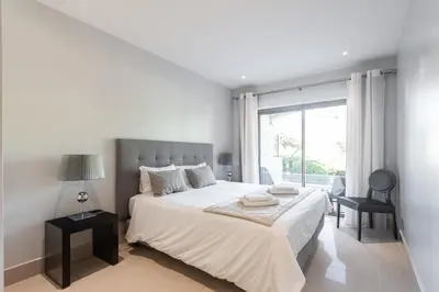 a white bedroom with a bed and a window at Vilamoura Pine Hills Villa in Vilamoura