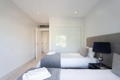 a bedroom with two beds and a window at Vilamoura Pine Hills Villa in Vilamoura
