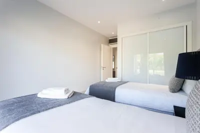 two beds in a bedroom with a large window at Vilamoura Pine Hills Villa in Vilamoura