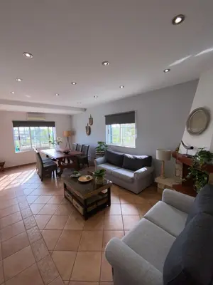 a kitchen with wooden cabinets and a table at Moradia a 5 minutos da PRAIA in Albufeira