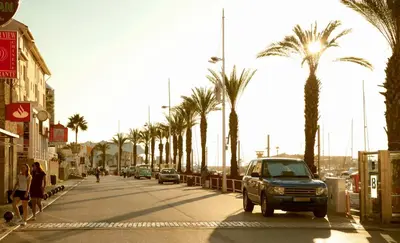 a car driving down a street with palm trees at Marina Plaza, Vilamoura in Vilamoura