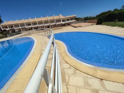 a large swimming pool in front of a building at Casa Felicidade in Albufeira