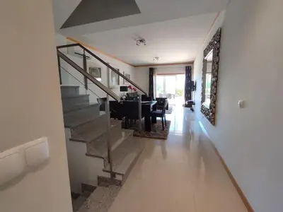 a living room with a staircase and a dining room at Casa Felicidade in Albufeira