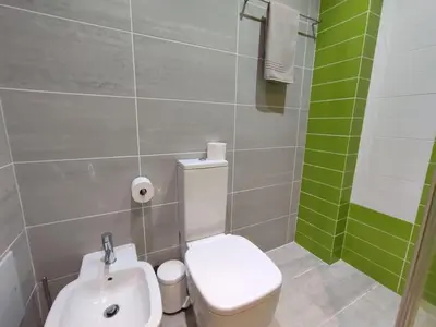 a bathroom with a white toilet and a sink at Casa Felicidade in Albufeira