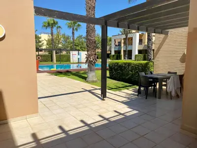 a patio with a table and chairs and a pool at Janelas do Oceano - Casa de Ferias T3 Vilamoura in Vilamoura
