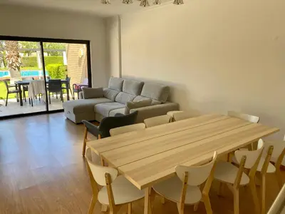 a living room with a wooden table and a couch at Janelas do Oceano - Casa de Ferias T3 Vilamoura in Vilamoura