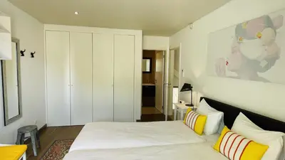 a bedroom with a white bed with yellow and white pillows at Praia by Check-in Portugal in Albufeira