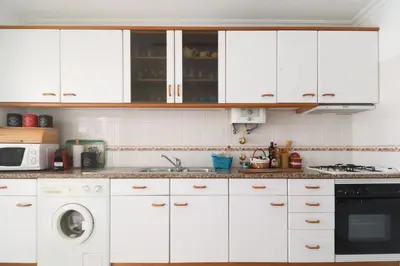 a kitchen with white cabinets and a dishwasher at Apartamento Sea Shell in Albufeira