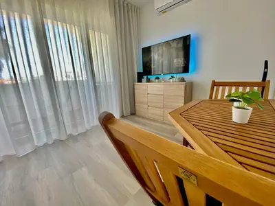 a dining room with a table and a television at Fresh and cosy appt with Pool, Fiber, LargeTV, Gaming Room in Albufeira