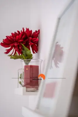 a vase with a red flower sitting on a shelf at #092 Quinta dos Figos by Home Holidays in Albufeira