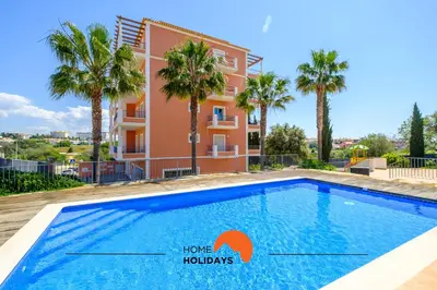 a villa with a swimming pool and palm trees at #092 Quinta dos Figos by Home Holidays in Albufeira