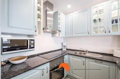 a kitchen with white cabinets and a sink at #086 Fish House by Home Holidays in Albufeira