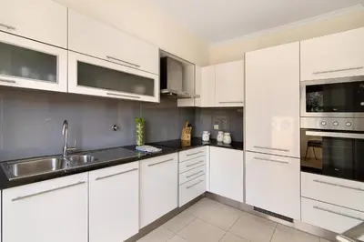 a white kitchen with white cabinets and a sink at Albufeira Townhouse beach in Albufeira