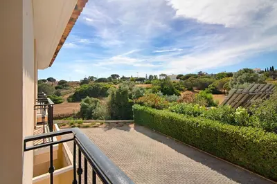 a balcony with a view of a garden at Albufeira Townhouse beach in Albufeira
