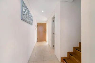a hallway of a house with white walls and a staircase at Albufeira Townhouse beach in Albufeira