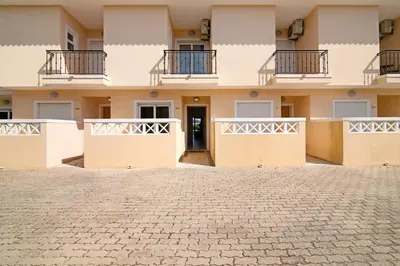 a building with balconies and a cobblestone courtyard at Albufeira Townhouse beach in Albufeira