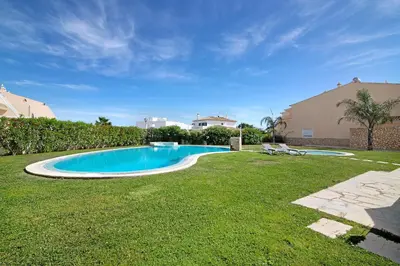 a swimming pool in the yard of a house at Albufeira Townhouse beach in Albufeira