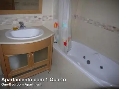 a bathroom with a sink and a bath tub at Akisol Albufeira Rainbow in Albufeira