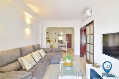 a living room with a couch and a tv at Onda Azul by MTPhomes in Albufeira
