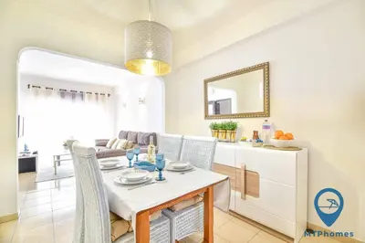 a dining room with a white table and chairs at Onda Azul by MTPhomes in Albufeira