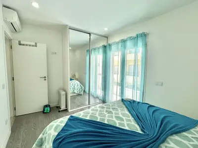 a bedroom with a bed and a large glass window at Nutmeg - 50mtrs to beach - by HD PROPERTIES in Quarteira