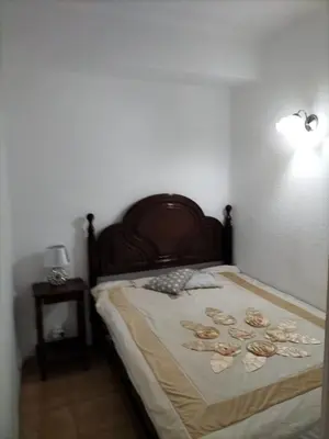 a bedroom with a bed with a wooden headboard at Apartamento Maria do Céu Villa Magna in Albufeira