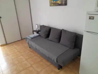 a gray couch in a room with a refrigerator at Apartamento Maria do Céu Villa Magna in Albufeira