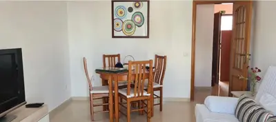 a dining room table and chairs in a living room at Quarteira beach house in Quarteira