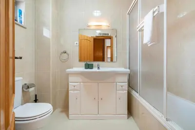 a bathroom with a sink and a toilet and a shower at Quarteira beach house in Quarteira