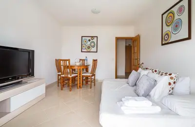 a living room with a white couch and a table at Quarteira beach house in Quarteira