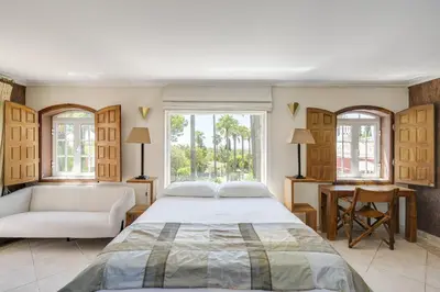a bedroom with a large bed and a couch at Villa Oasis by CadenzaLux in Almancil