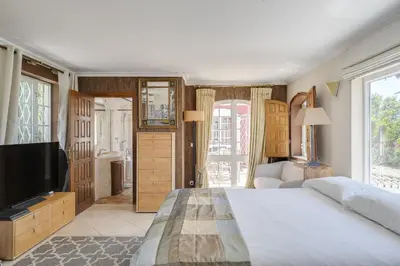 a bedroom with a large bed and a fireplace at Villa Oasis by CadenzaLux in Almancil