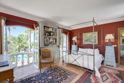 a bedroom with red walls and a bed with white sheets at Villa Oasis by CadenzaLux in Almancil