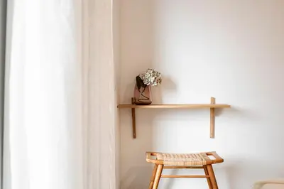 a wooden shelf on a wall next to a wooden stool at CATCH - Vilamoura in Vilamoura