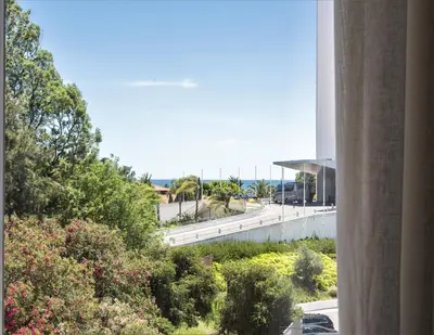 a view of a road from a building with trees and flowers at CATCH - Vilamoura in Vilamoura