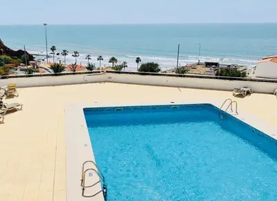 a swimming pool with a view of the beach at On The BEACH Stunning Apartment Albufeira Olhos de Água in Albufeira
