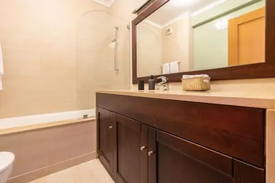 a bathroom with a sink and a mirror and a tub at Vilamoura Hideaway - Golf, Pool & Beach in Vilamoura