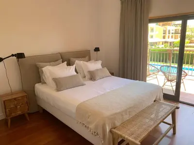 a bedroom with a large white bed with a balcony at Vilamoura Hideaway - Golf, Pool & Beach in Vilamoura