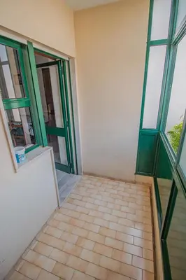 an empty room with green windows and a tiled floor at Charming Private Rooms in an Apartment A2 Penha - Faro in Faro