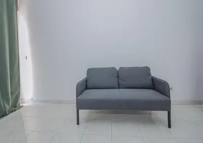 a gray couch sitting in a room with a white wall at Charming Private Rooms in an Apartment A1 Penha - Faro in Faro